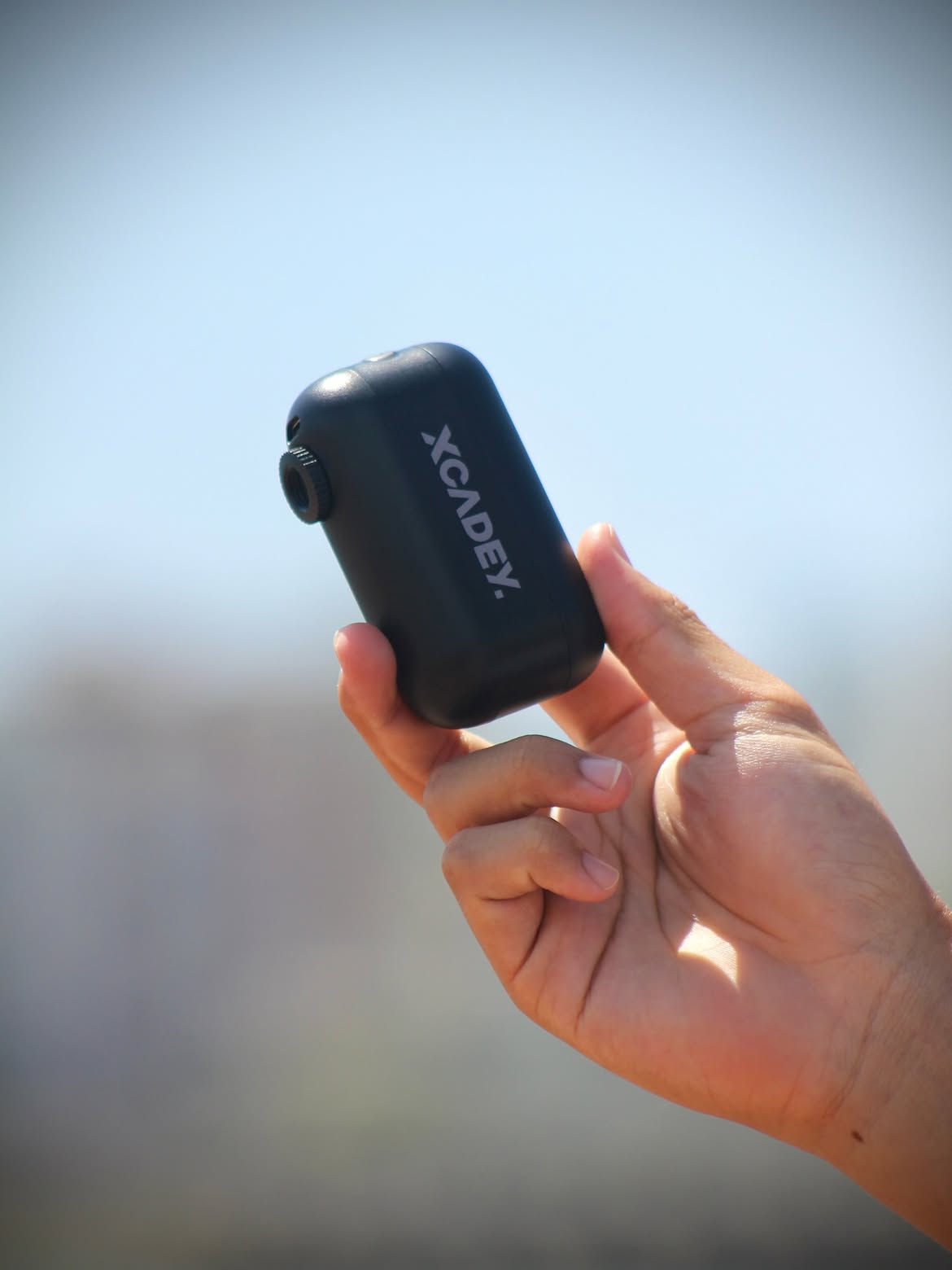 Gravel cyclist riding with a portable mini electric bike pump