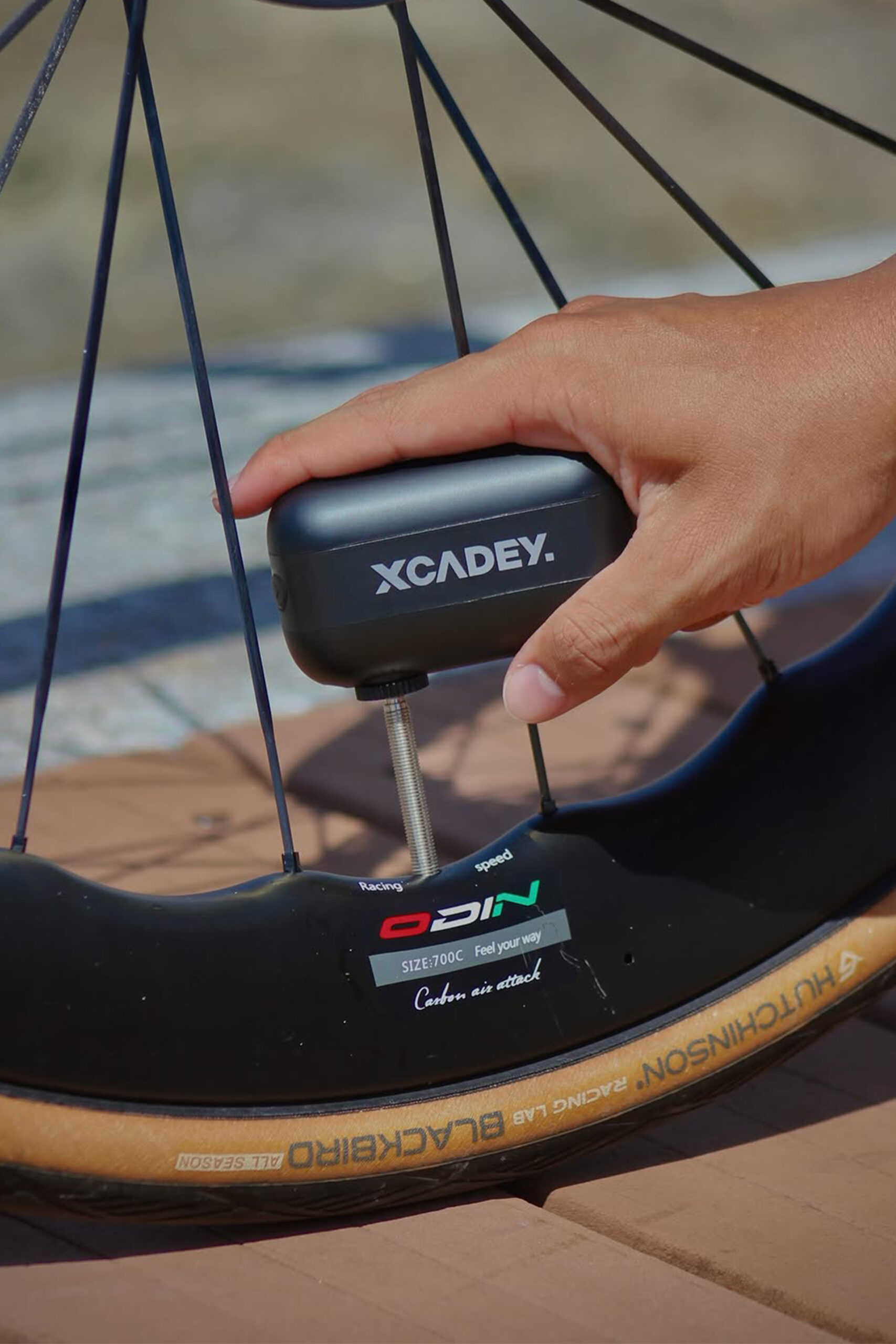 Road cyclist carrying a compact electric bike pump for roadside tire inflation