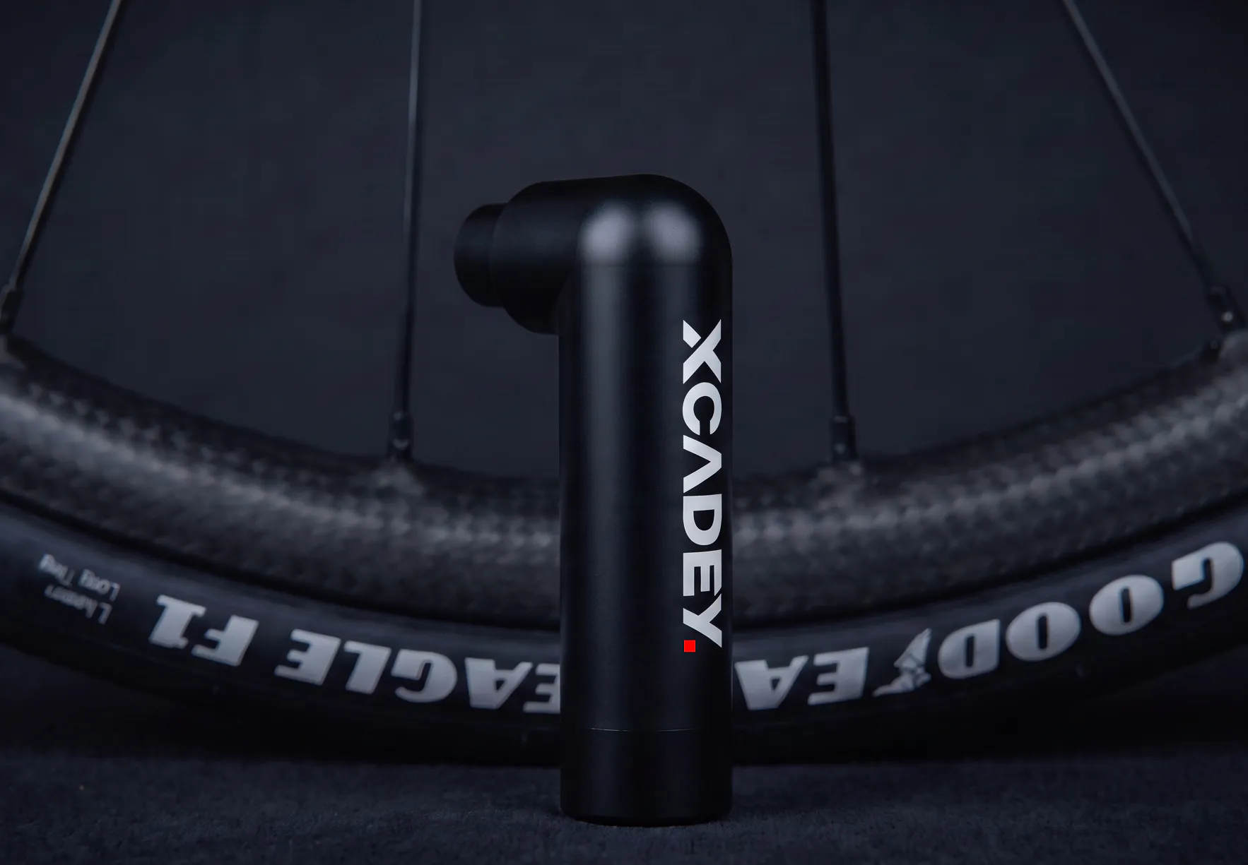 XCADEY CAPSULE P80 electric bike pump beside bicycle wheel
